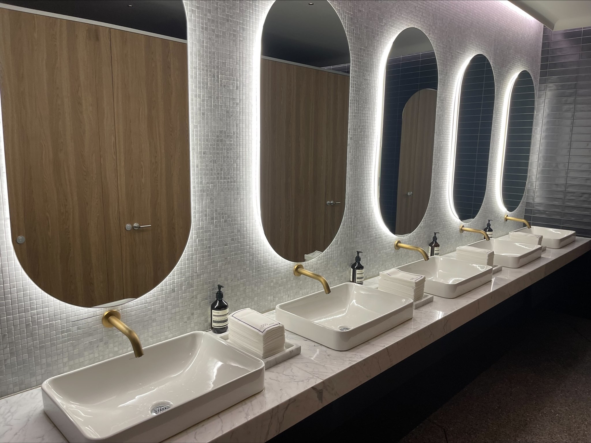 550 Madison Avenue commercial office restroom in New York, with wall-mounted sensor faucets